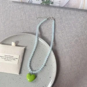 Pale blue beads, green heart / خرز أزرق فاتح وقلب أخضر